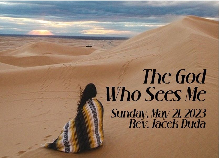 Woman seated on desert sand dunes at sunset with text: “The God Who Sees Me” and “Sunday, May 21, 2023”