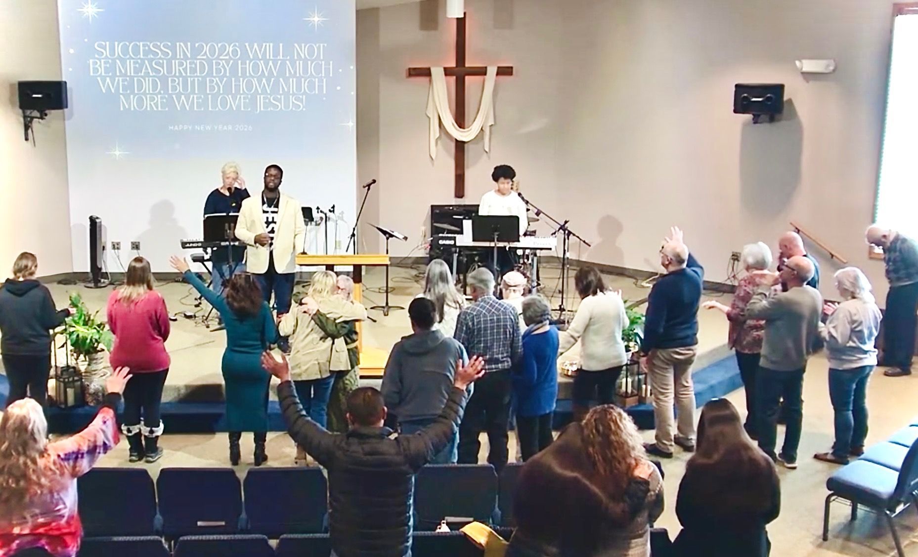 People standing and singing in a church sanctuary during a worship service