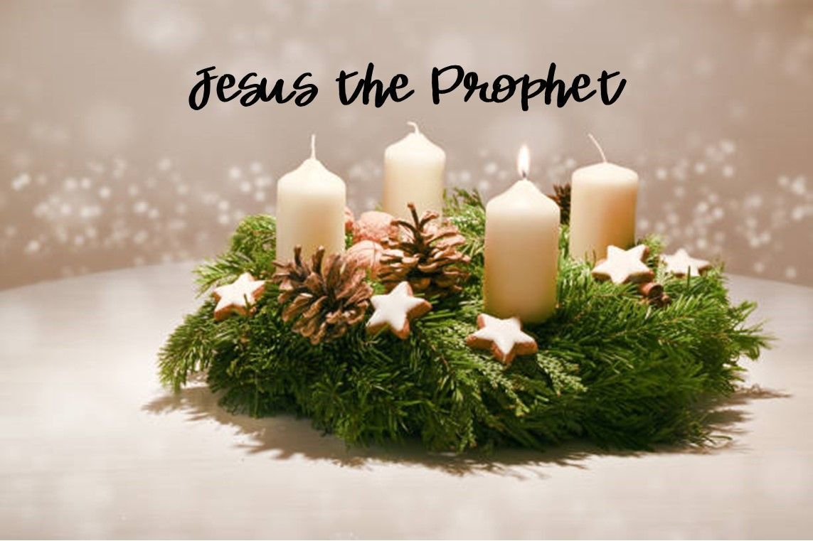 A christmas wreath with four candles and pine cones on a table.