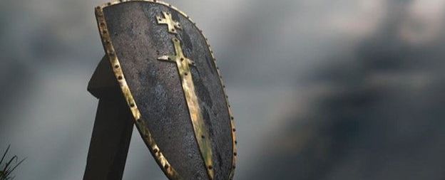 A shield with a cross on it is sitting on a wooden stand.