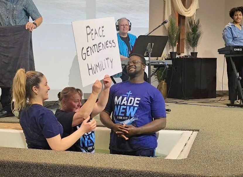Protesters in a church hold a sign reading “Peace, Gentleness, Humility” during a worship service.