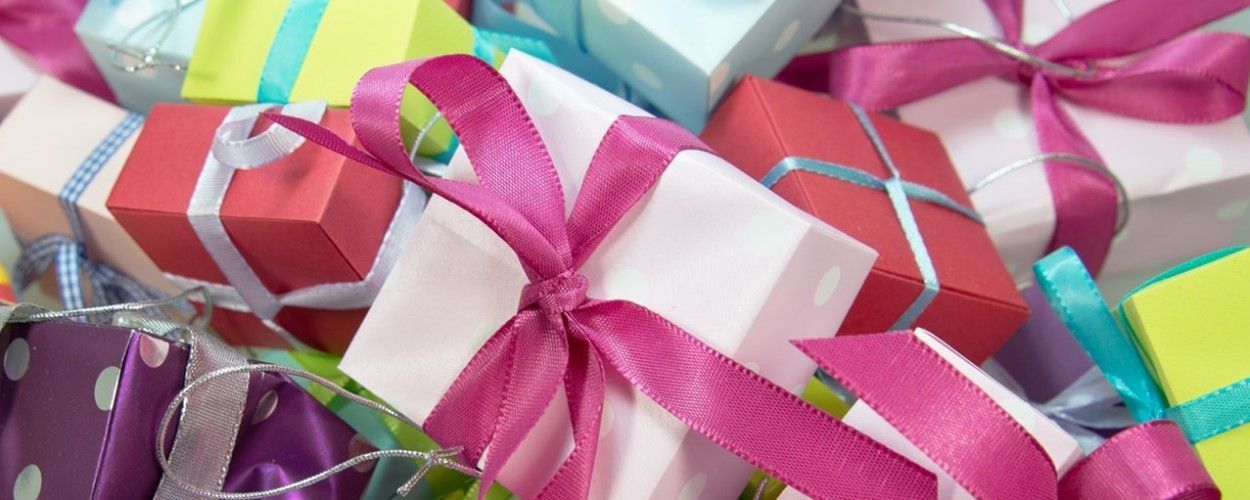 A pile of colorful gift boxes with ribbons and bows.