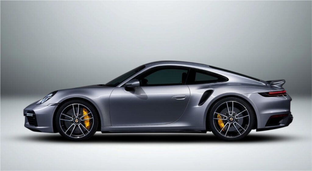 Um porsche 911 turbo s prateado está sobre uma superfície branca.