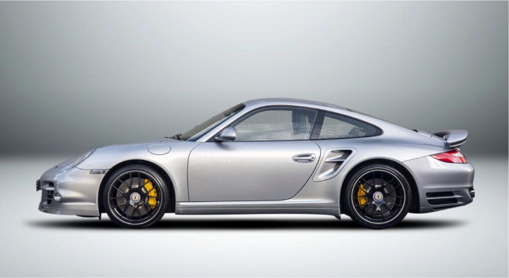Um porsche 911 turbo prateado é mostrado de lado em um fundo branco.