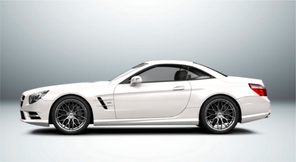 Um carro esportivo branco com rodas pretas está sentado em uma superfície branca.