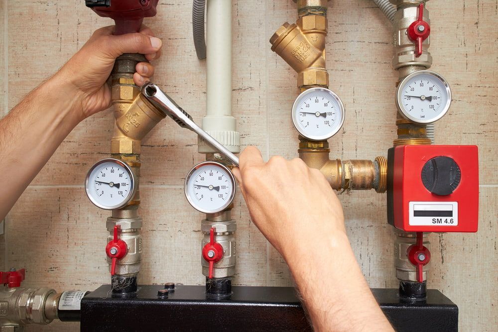 A Person Is Working On A Heating System With A Wrench — Matt Walsh Plumbing in Jindera, NSW