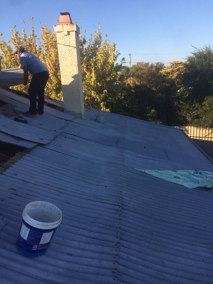 A Man Is Working On A Roof — Matt Walsh Plumbing in Thurgoona, NSW