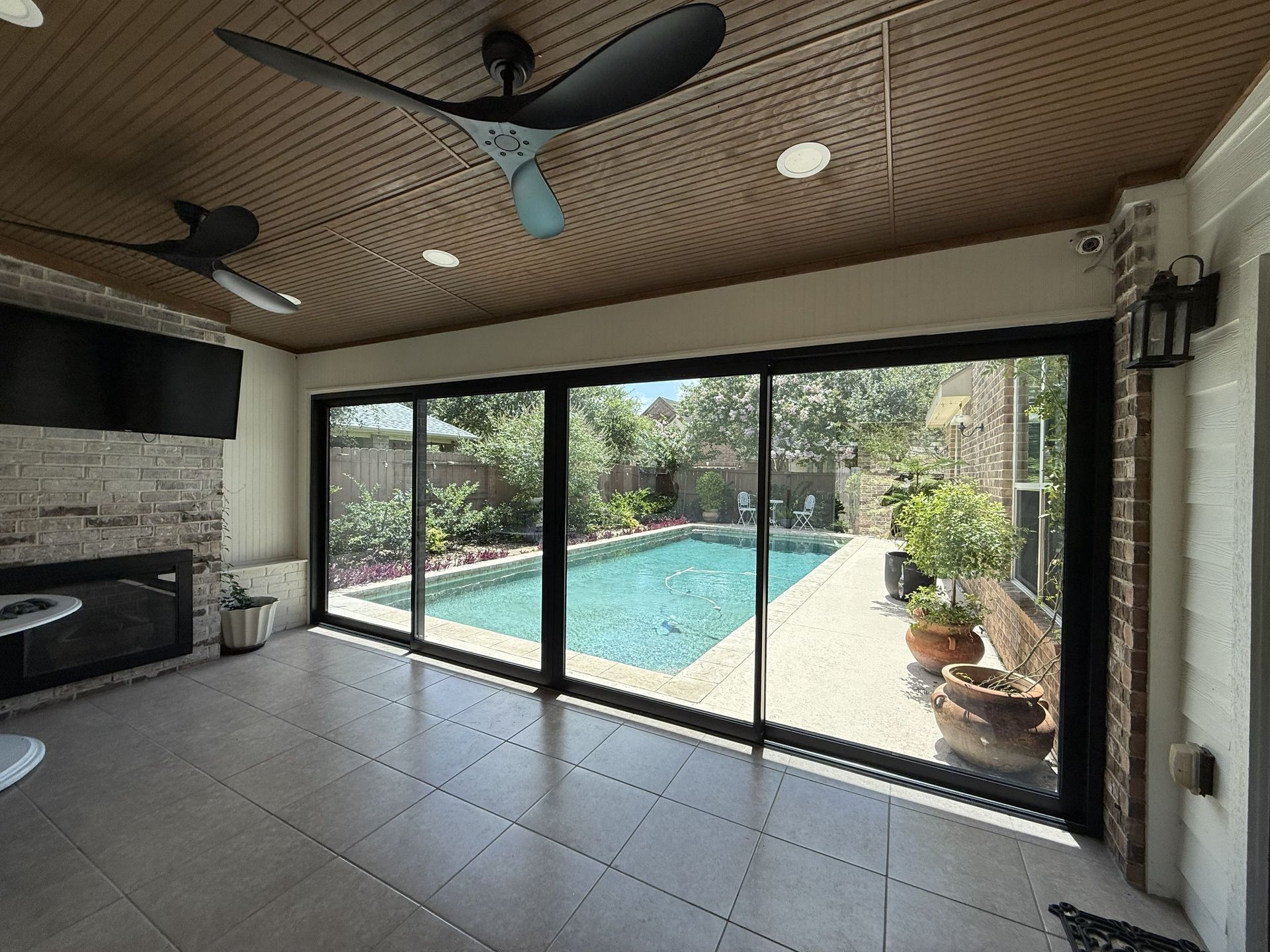 Covered patio overlooking a turquoise pool through large sliding glass doors