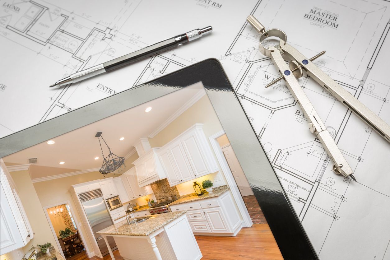 Tablet displaying a kitchen interior design plan with drafting tools on blueprints