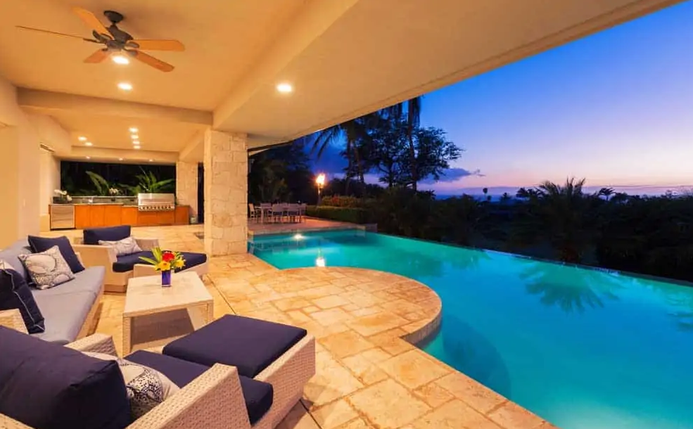 There is a swimming pool in the backyard of a house.
