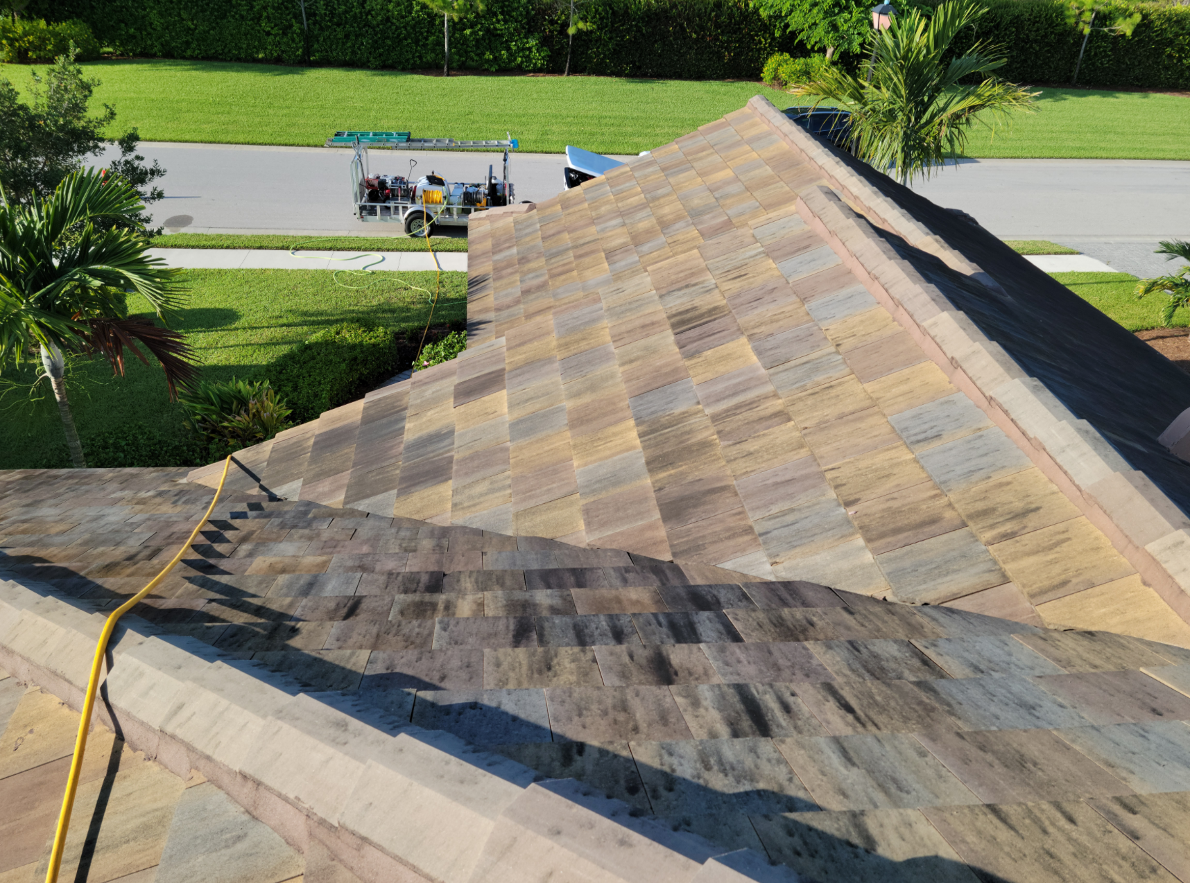 The roof of a house is being cleaned with a hose.