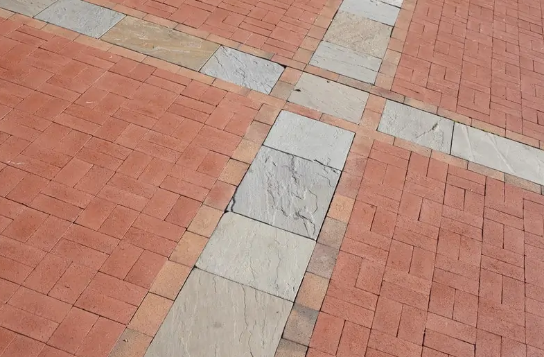 A close up of a brick walkway with a white border