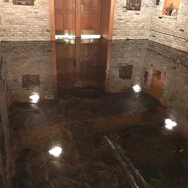 Room with dark floor reflecting lights and wooden double doors at the far end