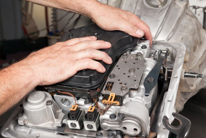 A man is working on a car engine in a garage.