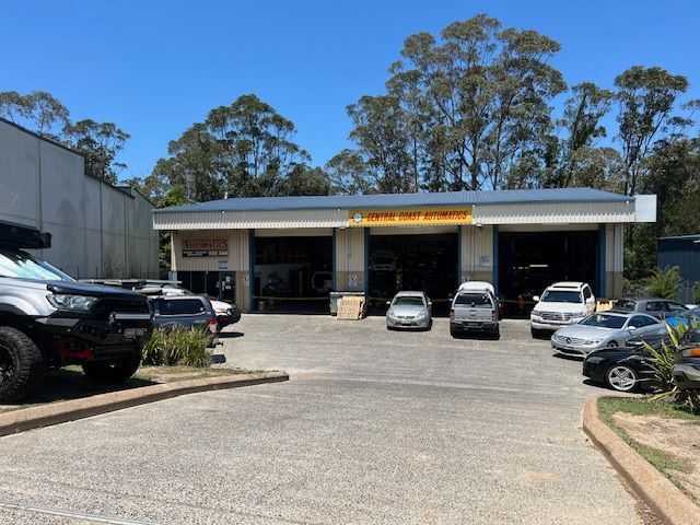 A lot of cars are parked in front of a garage