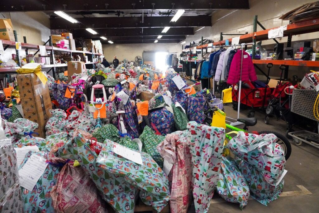 A store aisle crowded with colorful wrapped gifts and shelves of merchandise.