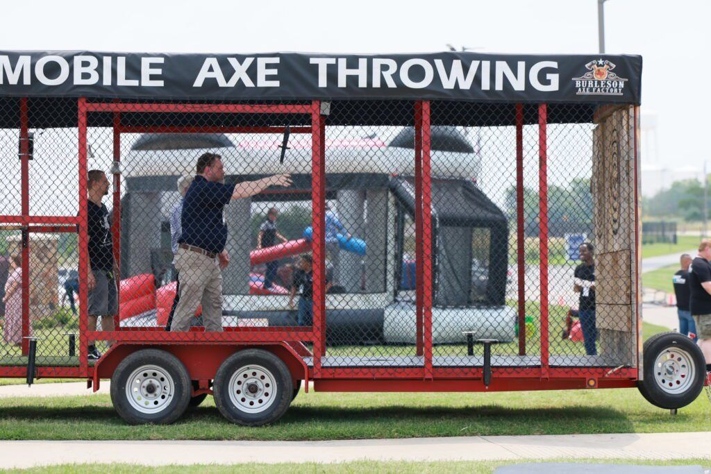 Mobile axe-throwing trailer with two people inside and targets on the side