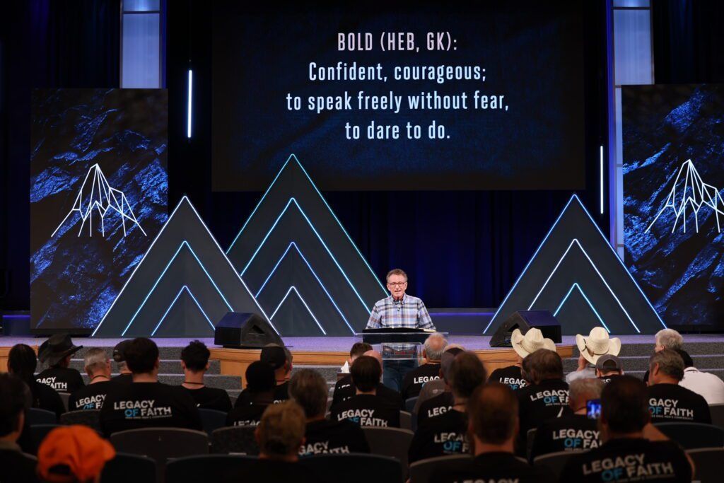 Speaker on stage beneath large screen