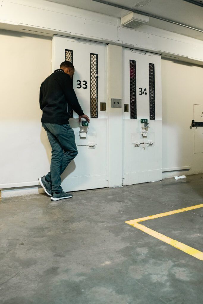 Person using a hand truck beside white industrial doors labeled 33 and 34 in a warehouse corridor