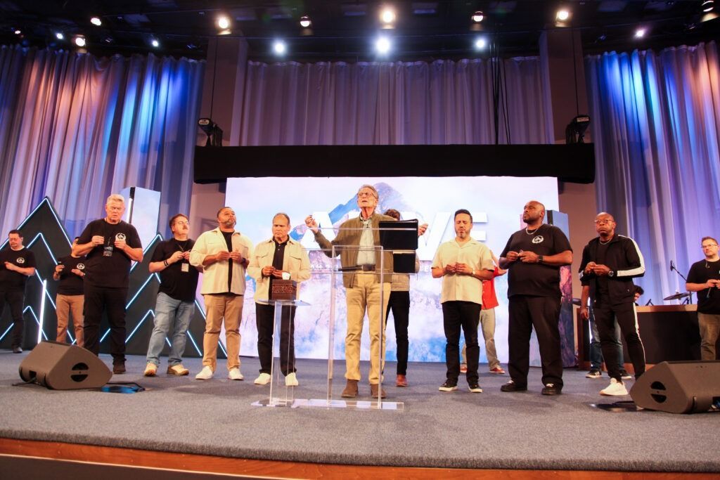People standing on a stage with microphones during a group performance or presentation