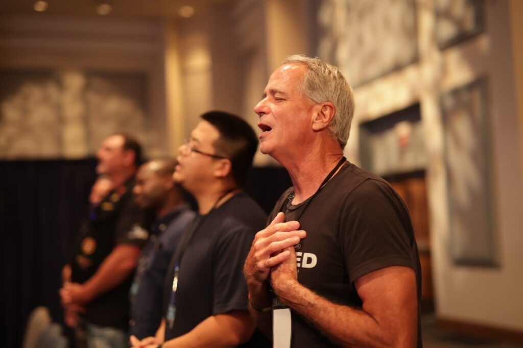 People singing or speaking together in a warmly lit indoor gathering