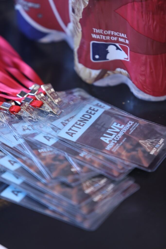 Stack of clear name badges with red clips beside a red tote bag on a table
