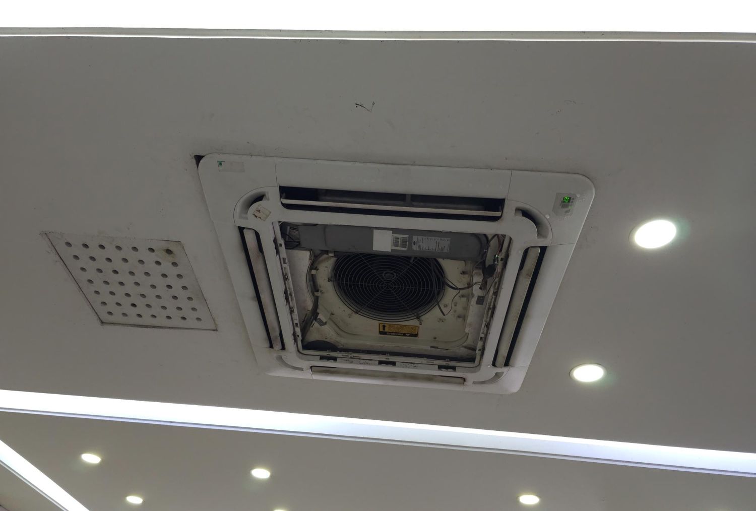 A broken ceiling air conditioner of a room.