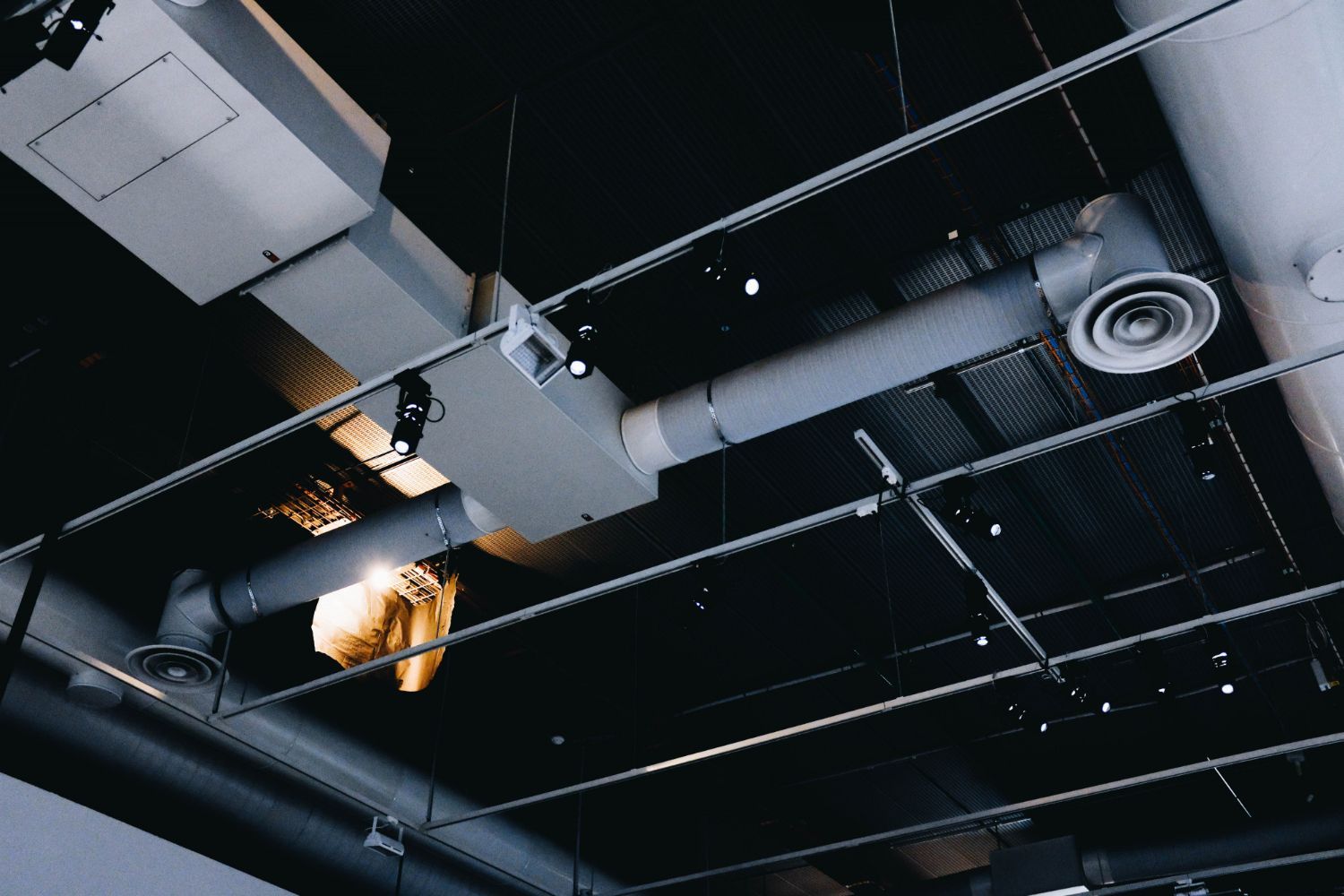 A ceiling with a lot of pipes hanging from it.