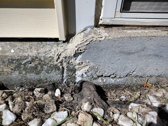 A close up of a concrete foundation next to a window.