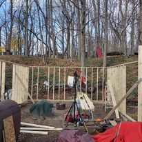 A wooden structure is being built in the woods.
