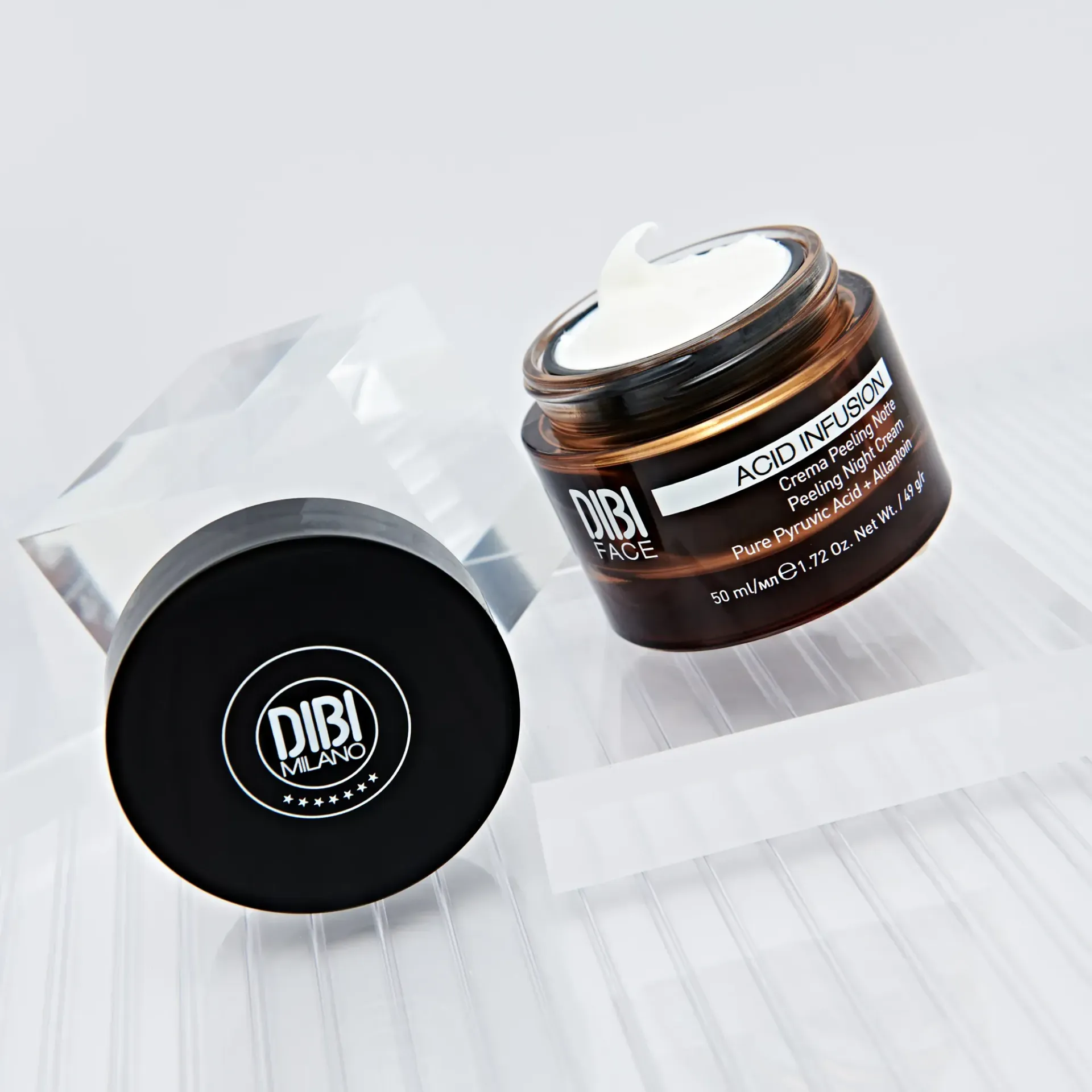 Due vasetti di crema viso DIBI Milano, uno aperto con la crema, l'altro con un coperchio nero