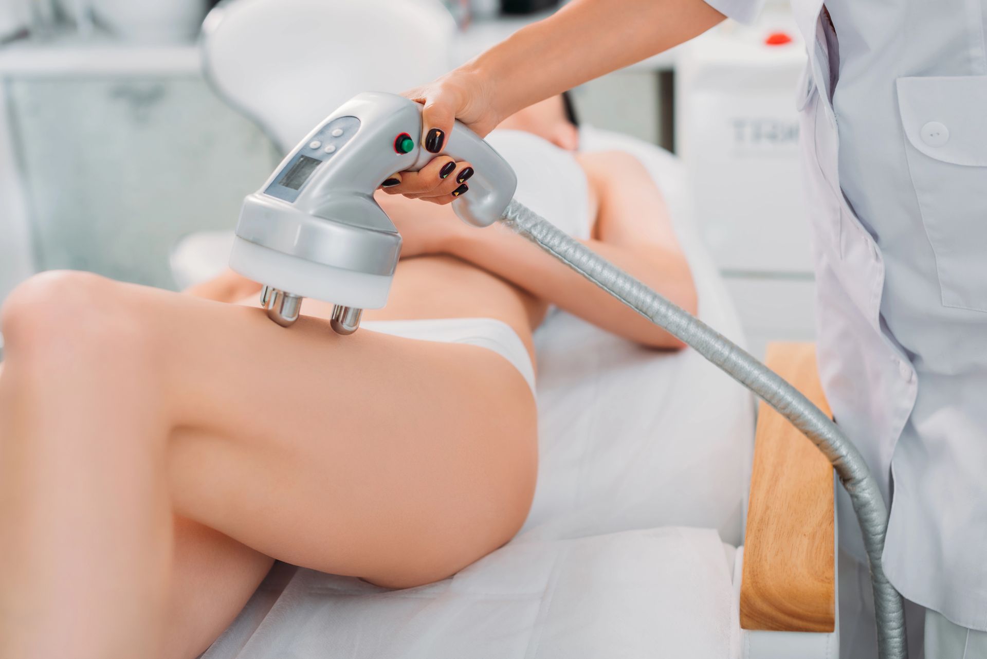 Una persona si sottopone a un trattamento di body contouring sulla coscia in una spa.
