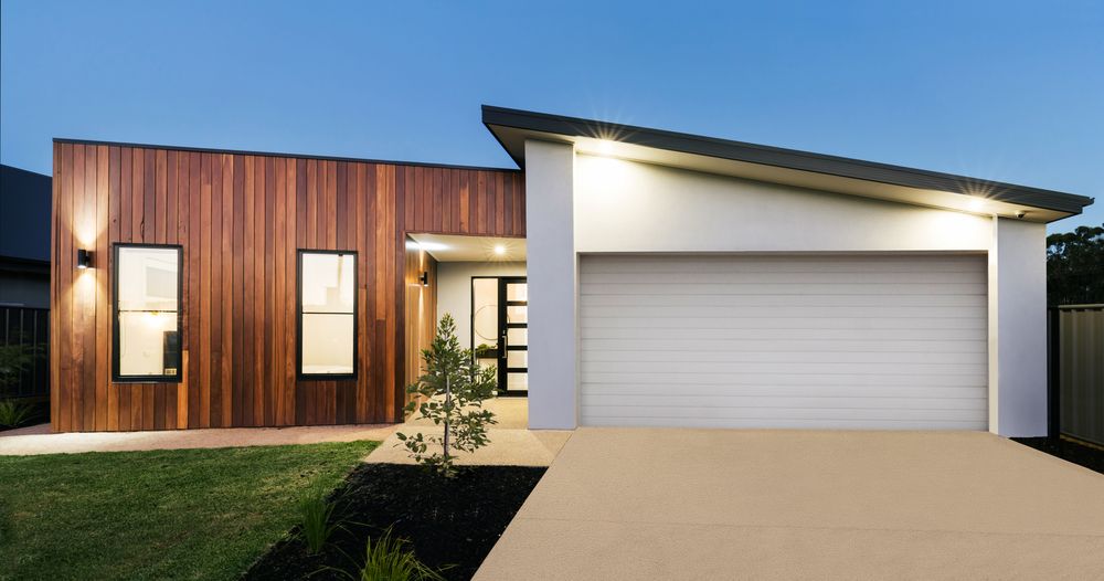 A modern house with a white garage door and wooden siding.