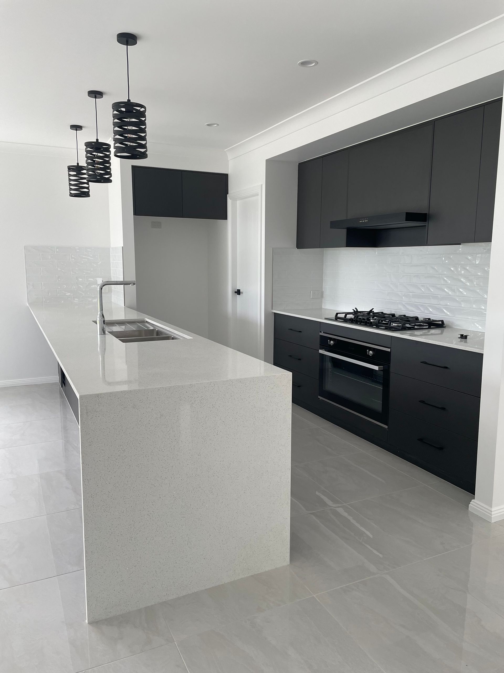 A kitchen with black cabinets and a white counter top