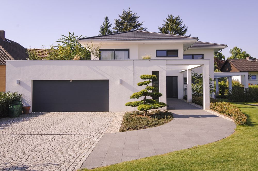 A large white house with a black garage door
