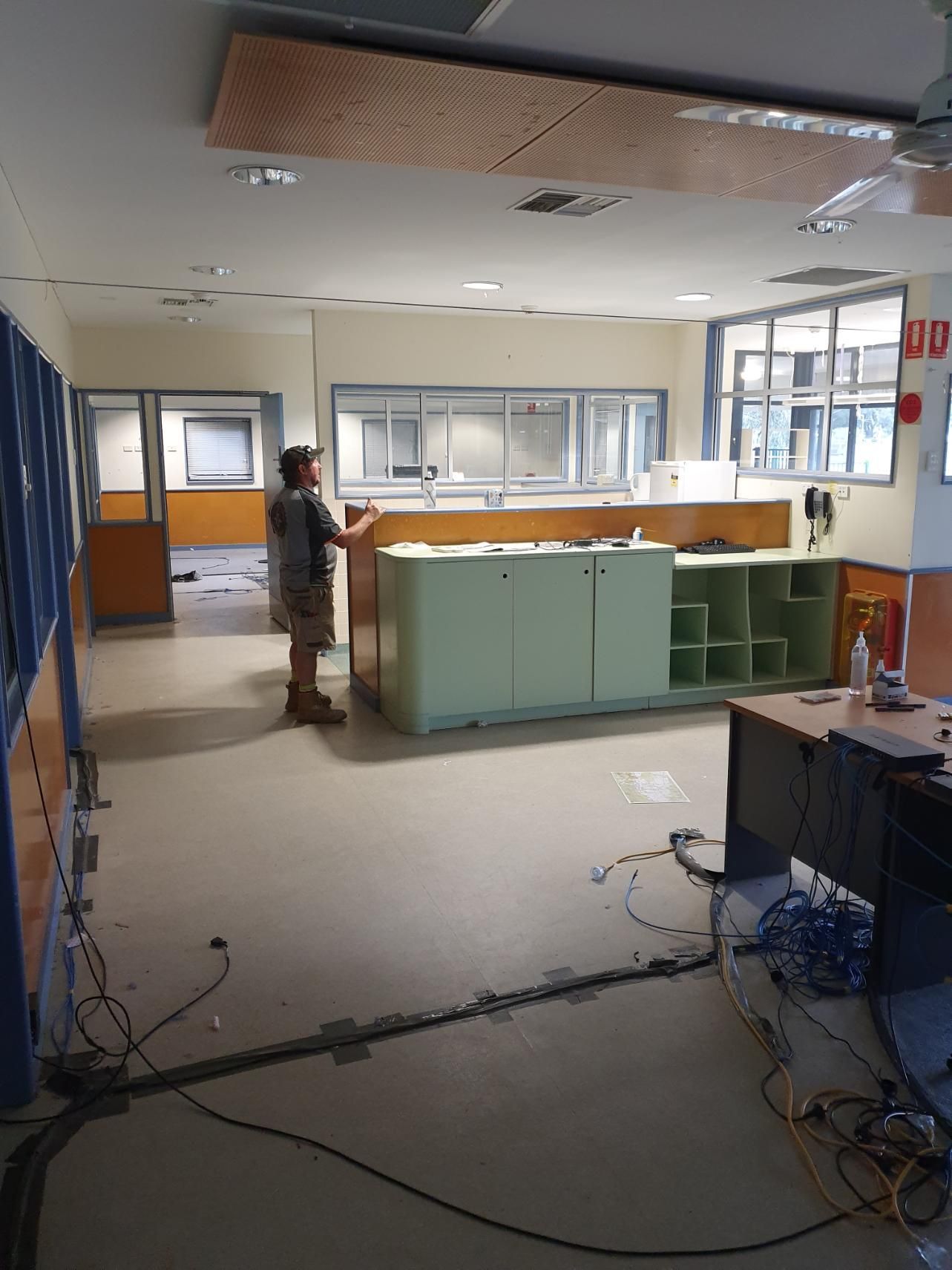 A Man Is Standing in A Room with A Sign — Entire Trades in Maitland, NSW