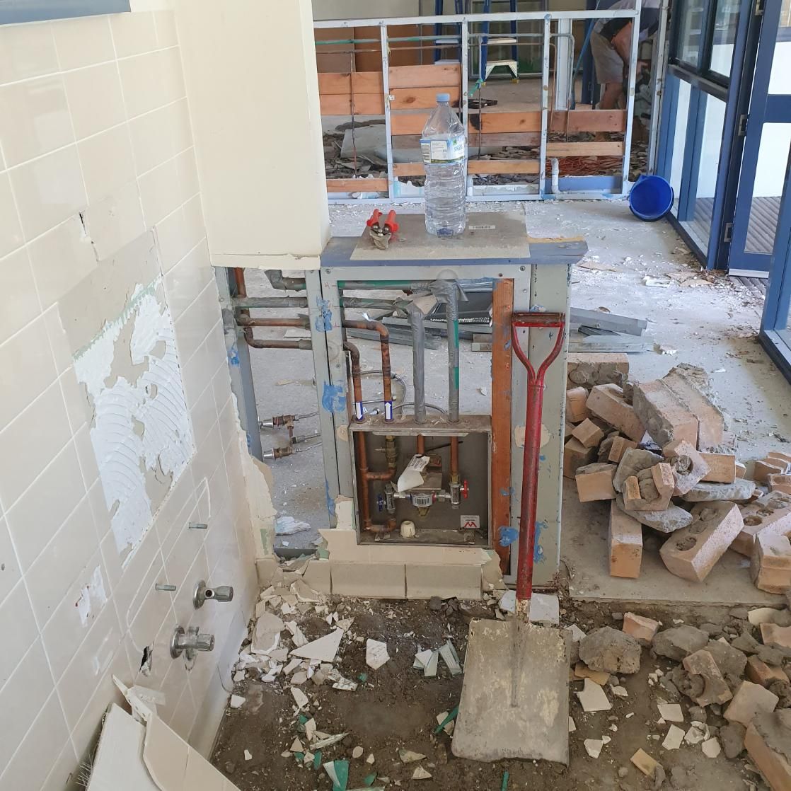 A Bathroom Under Construction with A Shovel and A Bottle of Water — Entire Trades in Singleton, NSW
