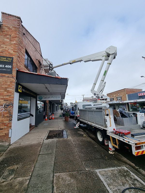 A Truck Positioned On The Roadside Installing Electrical Cable — Entire Trades in Port Stephens, NSW