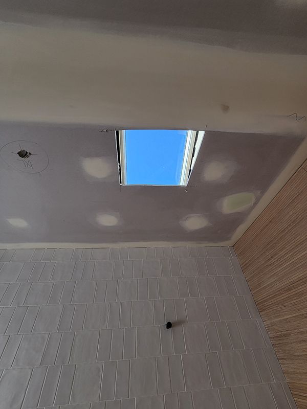 A Bathroom With A Window Showing A Blue Sky — Entire Trades in Singleton, NSW