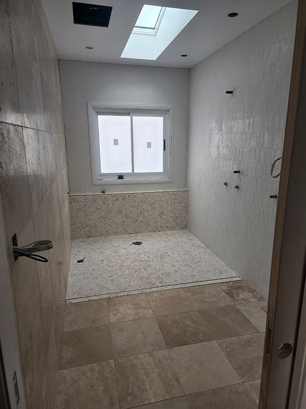 Bathroom With White Sink, Cabinet, Two Showers, And A Toilet — Entire Trades in Singleton, NSW