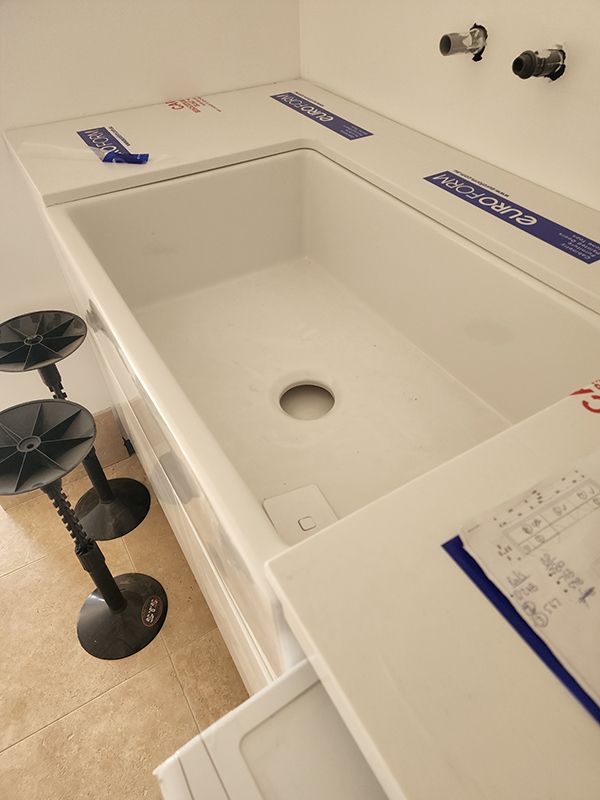 Modern Bathroom With White Bathtub, Sink, And Stools — Entire Trades in Cessnock, NSW