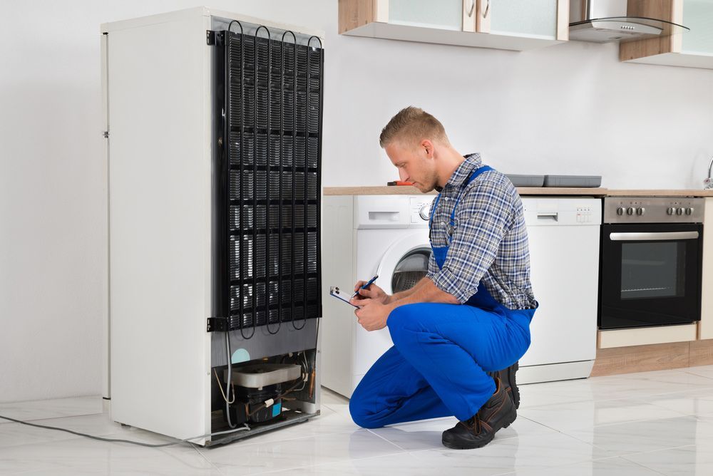 Writing On Clipboard In Front Of Refrigerator Appliance In Kitchen Room — Entire Trades in Central Coast, NSW