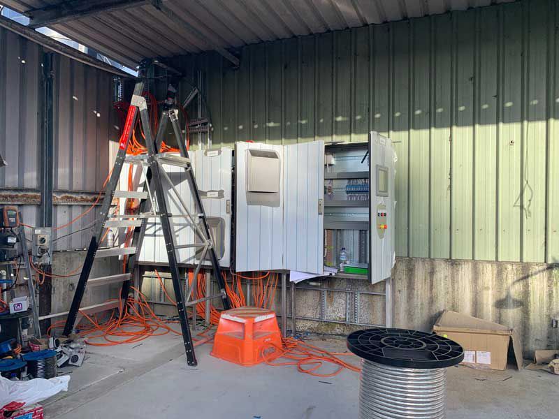 Large Electrical Panel Circuit Box Installation With Orange Wiring Cable — Entire Trades in Cessnock, NSW