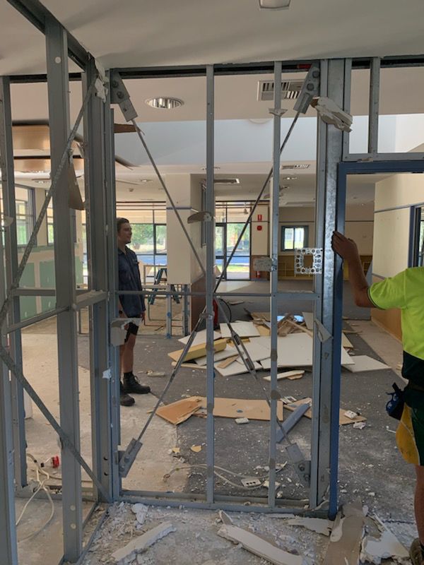 Two Men Constructing A Building With Metal Frames — Entire Trades in Port Stephens, NSW