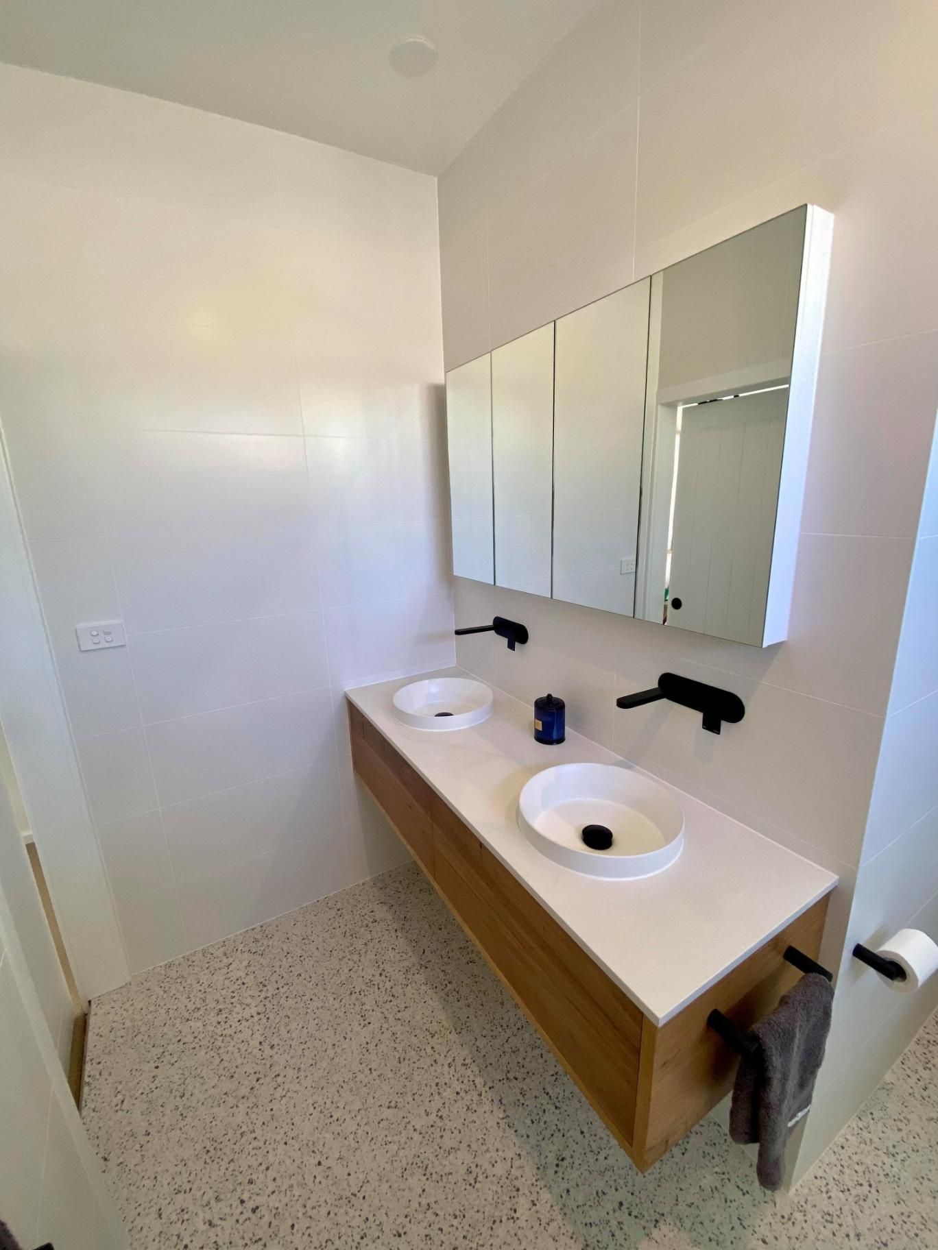A Bathroom with Two Sinks and A Mirror — Entire Trades in Maitland, NSW