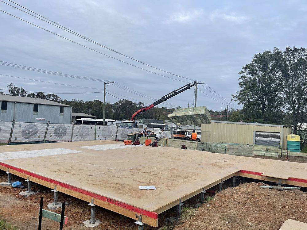 Construction Workers Focused On Building A Large Wooden Platform — Entire Trades in Port Stephens, NSW