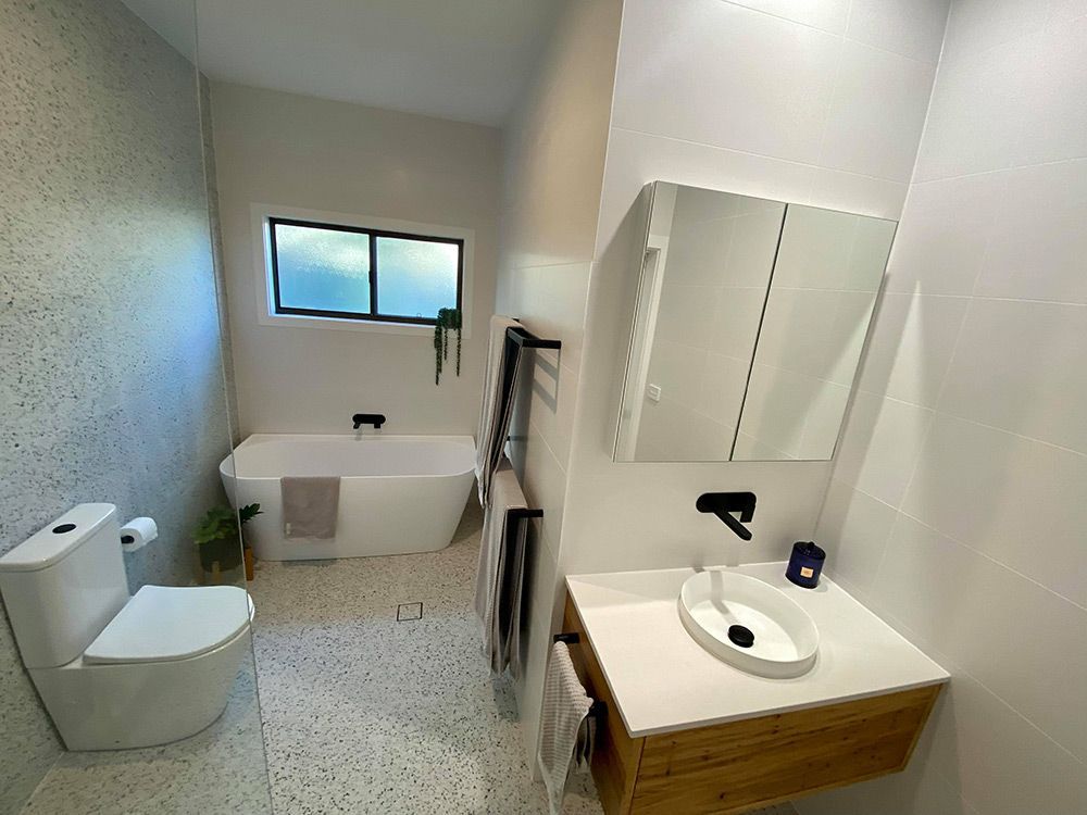 Modern Bathroom With A White Freestanding Bathtub — Entire Trades in Singleton, NSW
