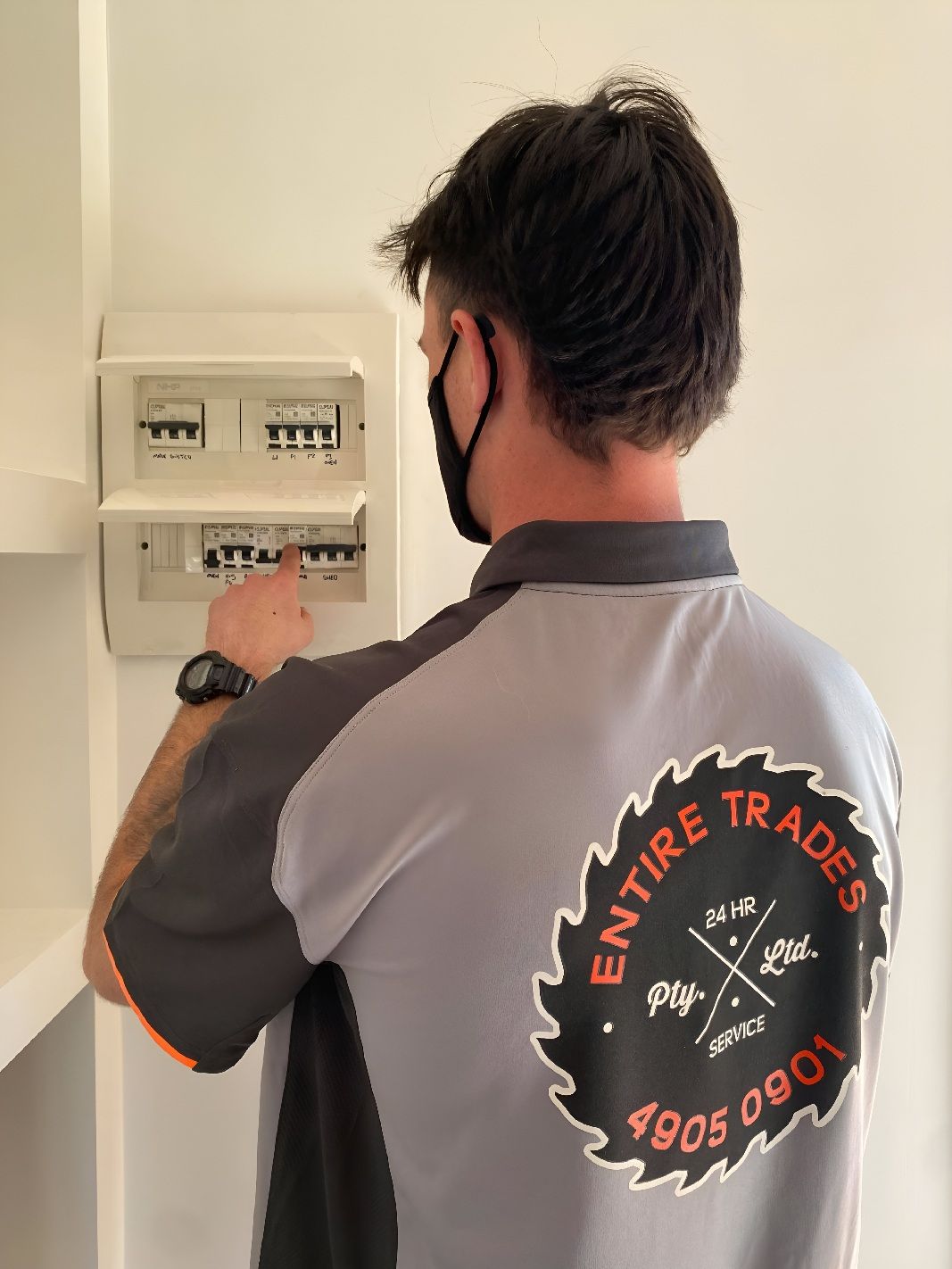 Electrician Inspecting An Electrical Panel Indoors — Entire Trades in Cessnock, NSW