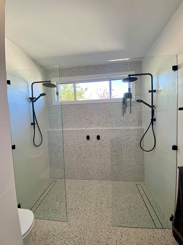 A Modern Bathroom With A Large Walk-in Shower Featuring A Dual Showerhead Setup — Entire Trades in Singleton, NSW