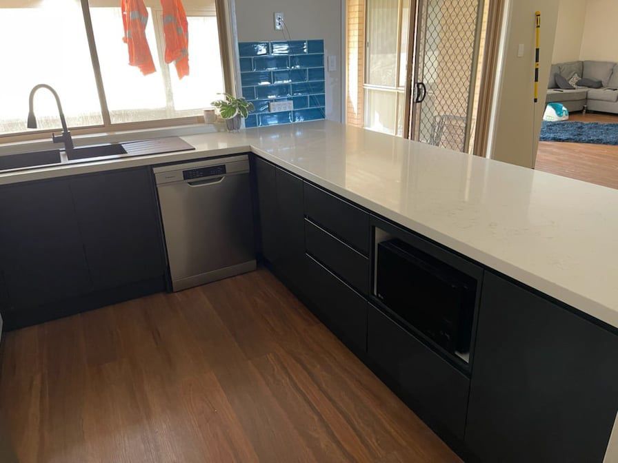 A Contemporary Kitchen Design With A Sleek White Countertop — Entire Trades in Port Stephens, NSW